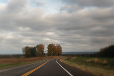 Empty road along countryside landscape