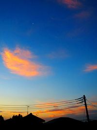 Low angle view of silhouette electricity pylon against romantic sky