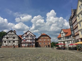 Buildings in town against cloudy sky