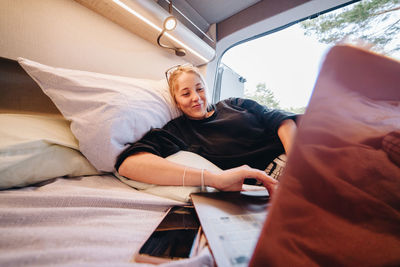 Young woman using laptop in camper