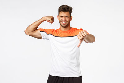 Portrait of young man standing against white background