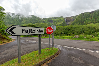 Information sign on road against sky