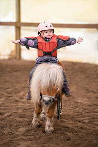 Rear view of woman with horse on field