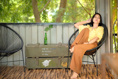 Woman looking away while sitting on chair