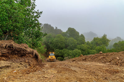 Working bulldozer clears area before construction. blue sky background