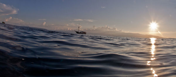 Scenic view of boat in water against cloudy sky