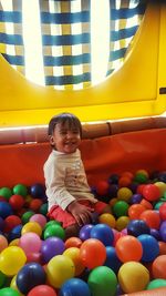 Portrait of happy boy sitting in ball pool