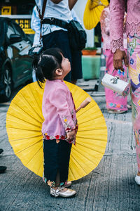 High angle view of siblings standing against yellow