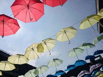 Low angle view of umbrellas hanging against sky