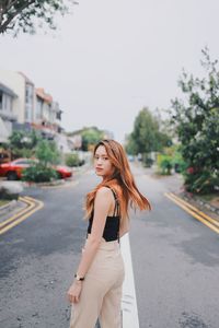 Woman standing on road in city