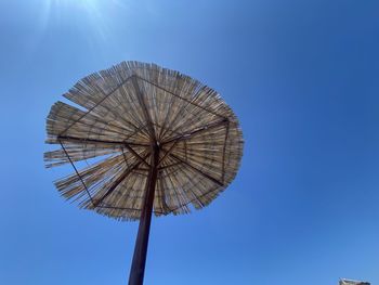 Low angle view of ferris wheel against clear blue sky