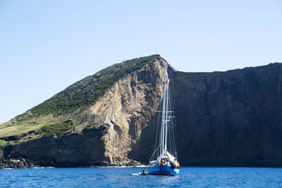 Sailboat sailing on sea against clear sky