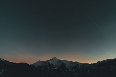 Scenic view of snowcapped mountains against sky during sunset