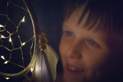 Close-up of boy holding illuminated dreamcatcher