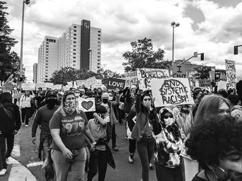 People on street in city against sky