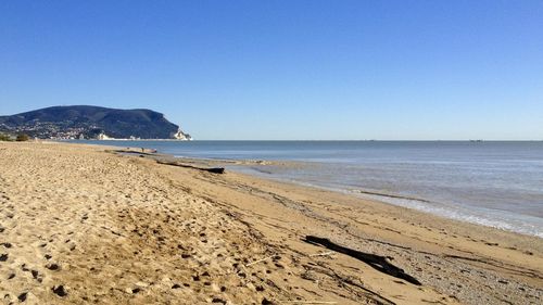Scenic view of beach against clear blue sky
