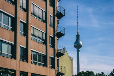 Buildings by fernsehturm against cloudy sky