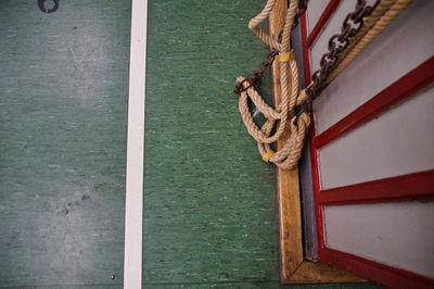 Close-up of rope tied on wooden post in gym