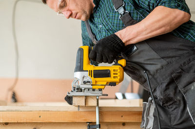 Midsection of man working at workshop