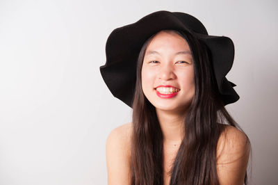 Portrait of smiling young woman against white background