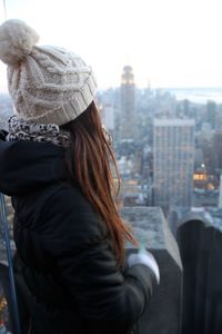 Rear view of woman in city against clear sky