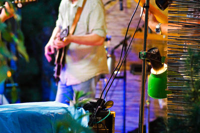 Midsection of guitarist performing at concert