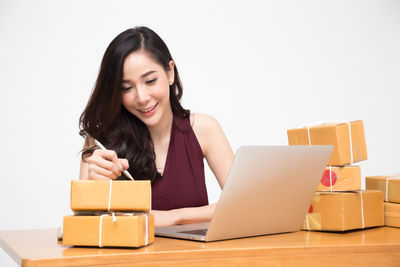 Portrait of smiling young woman using smart phone in box