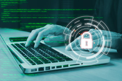 Digital composite image of hand using laptop