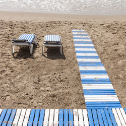 High angle view of empty lounge chairs at beach