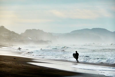 Man on beach against sky