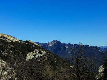 Scenic view of mountains against clear blue sky