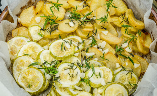 Slices of freshly baked potatoes and zucchini with dill and garlic