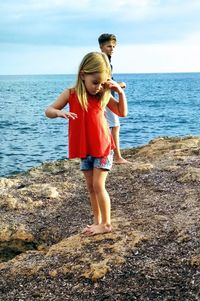 Full length of woman standing on beach against sea