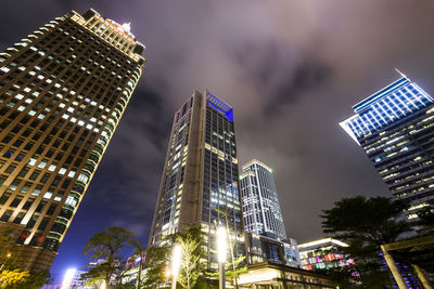 Low angle view of modern commercial buildings at night in taipei, taiwan.