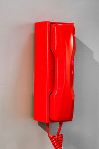 Close-up of red telephone on wall