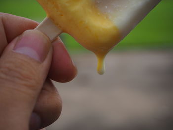 Close-up of hand holding melting ice cream