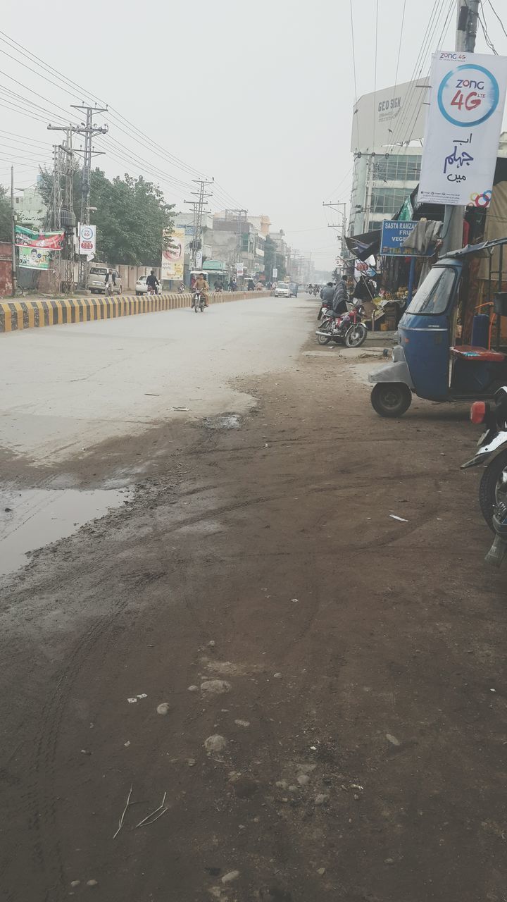 building exterior, built structure, architecture, transportation, beach, street, text, sand, car, mode of transport, land vehicle, city, western script, incidental people, road, sky, day, communication, outdoors, clear sky