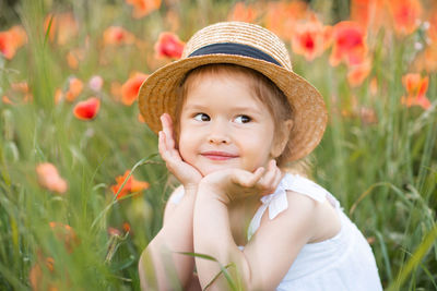 Cute girl wearing hat standing on field