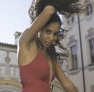 Close-up portrait of young woman standing against wall