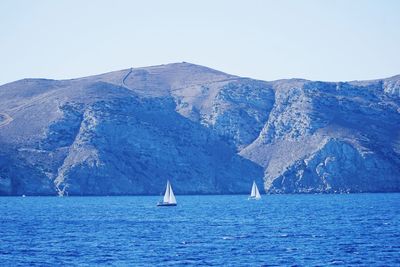 Sailboat sailing on sea against clear sky