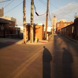 Road amidst buildings in city against sky