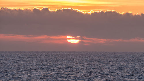 Scenic view of sea against orange sky