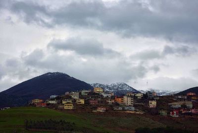 Houses on mountain against sky