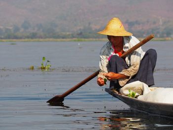 Man sitting on boat in lake