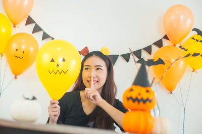 Woman looking at balloon during halloween celebration