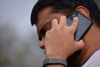 Close-up portrait of man holding mobile phone