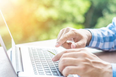 Cropped image of woman doing online shopping at desk