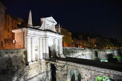 Illuminated buildings against sky in city at night