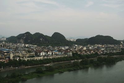 Scenic view of river by town against sky