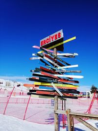 Low angle view of information sign against clear blue sky